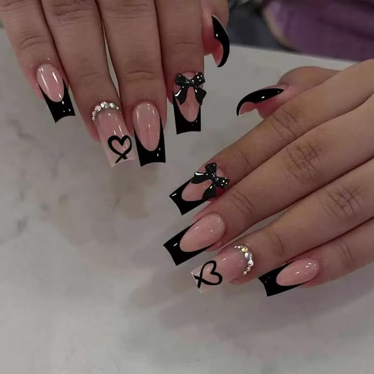 Pink almond French-tip nails with delicate gold outlines and rhinestone accents